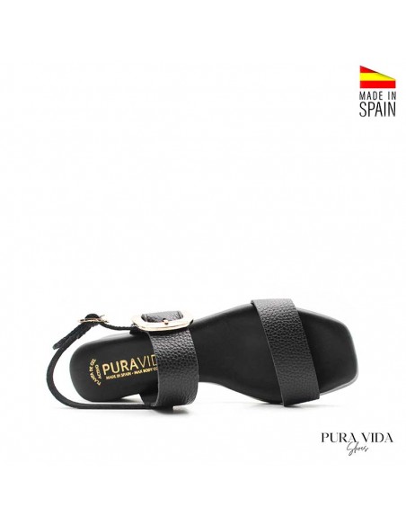 Detalle de sandalias negras de tacón bajo y tiras