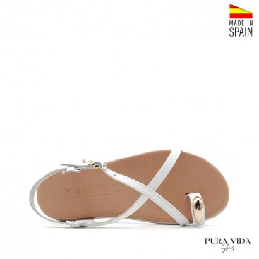 Sandalia blanca plana con anillo dorado en el dedo y suela flexible fabricada en España