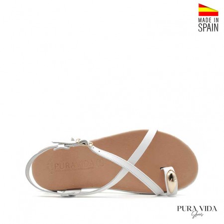 Sandalia blanca plana con anillo dorado en el dedo y suela flexible fabricada en España