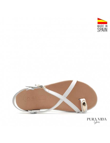 Sandalia blanca plana con anillo dorado en el dedo y suela flexible fabricada en España