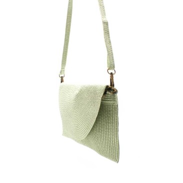 Bolso cartera sobre verde tipo rafia
