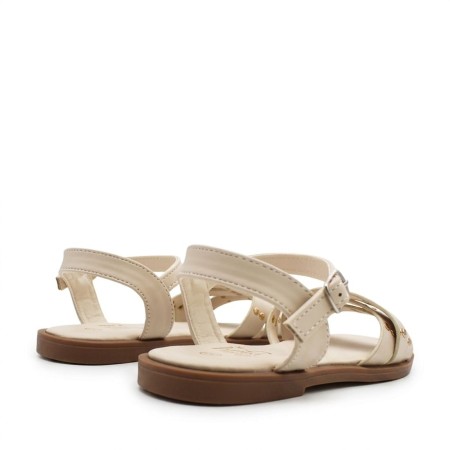 sandalias beige niña con detalle de tachuelas y diseño cruzado