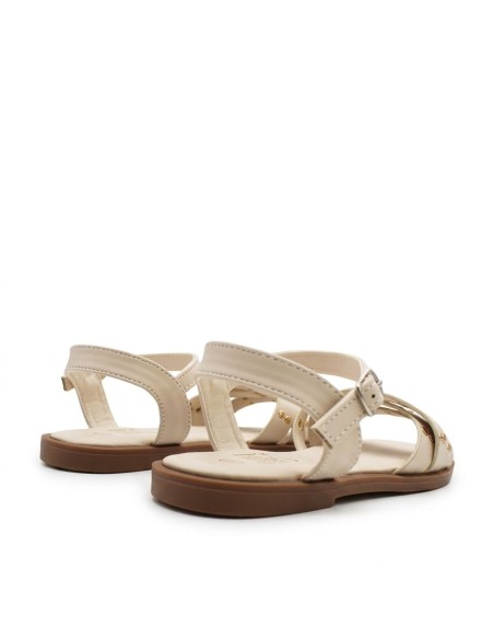 sandalias beige niña con detalle de tachuelas y diseño cruzado