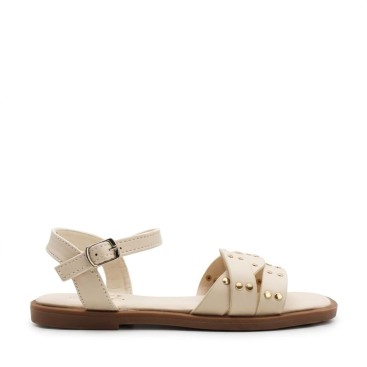 sandalias beige niña con tiras entrelazadas y tachuelas vista lateral