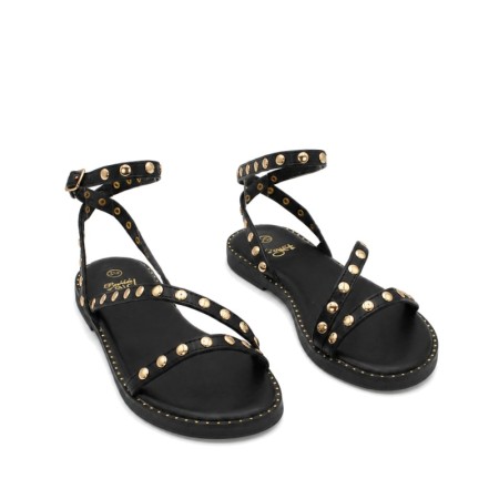 Sandalia infantil negra con detalles dorados.