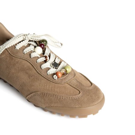 Detalle de cordones con abalorios en zapatilla casual camel mujer