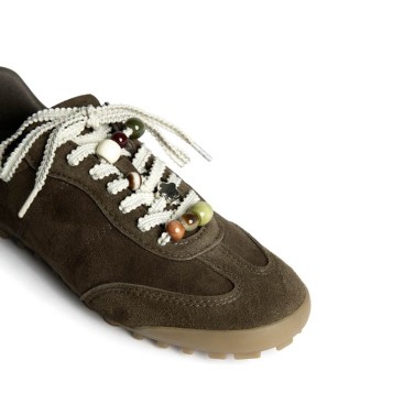 Detalle de abalorios en cordones de zapatilla casual verde kaki