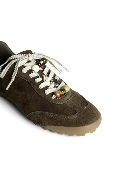 Detalle de abalorios en cordones de zapatilla casual verde kaki
